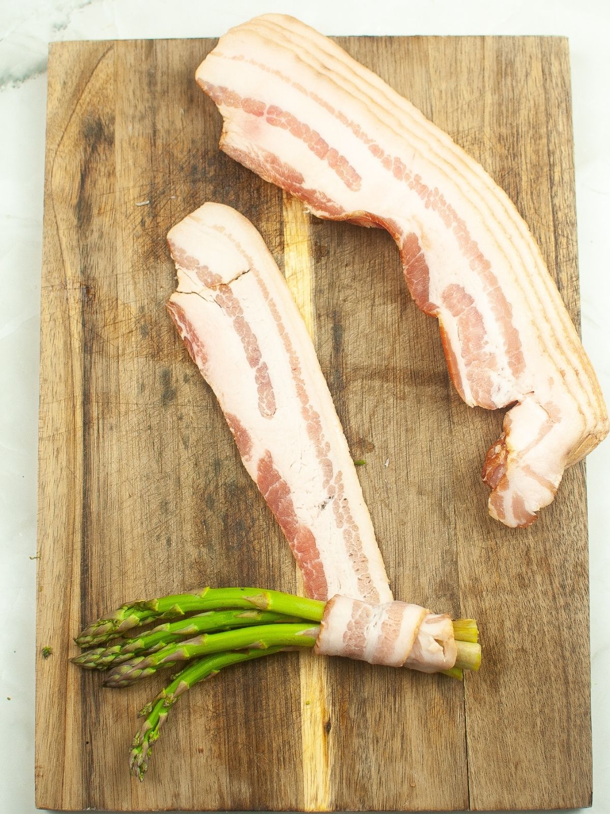 wrapping a bunch of asparagus in bacon.