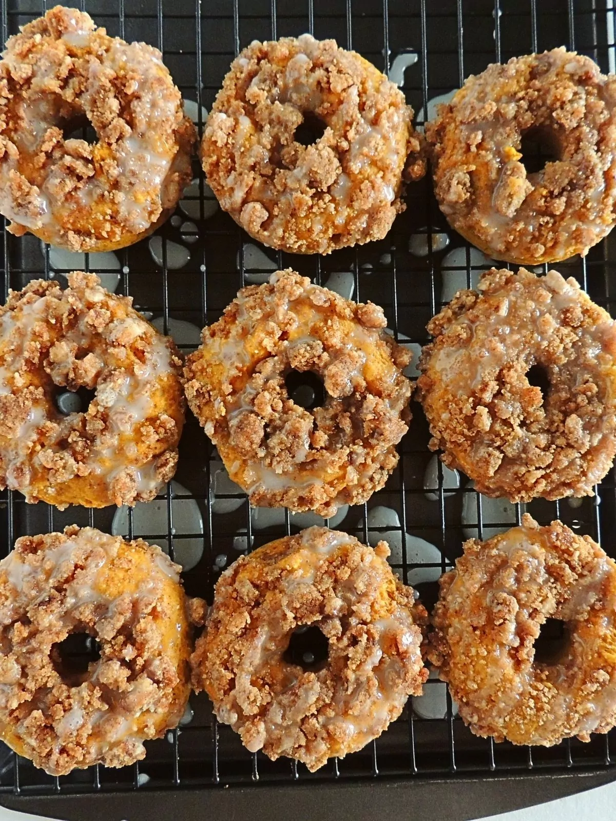 homemade pumpkin donuts with crumb topping and glaze.