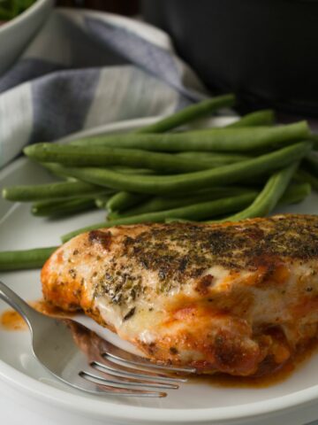 Chicken with mozzarella plated with fork.