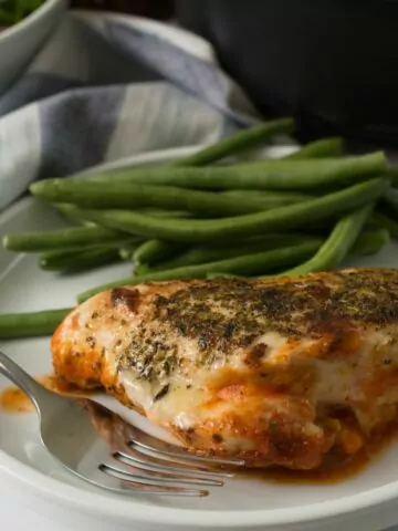 Chicken with mozzarella plated with fork.