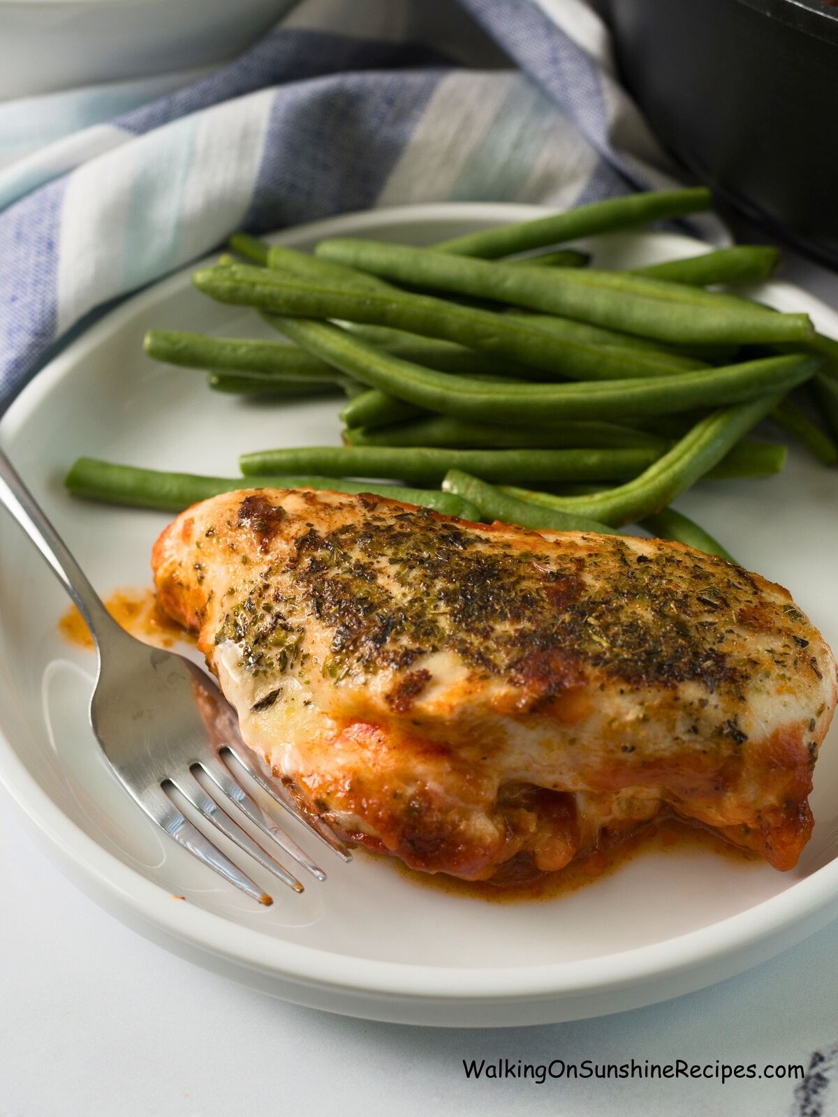 Mozzarella stuffed chicken breast on plate.