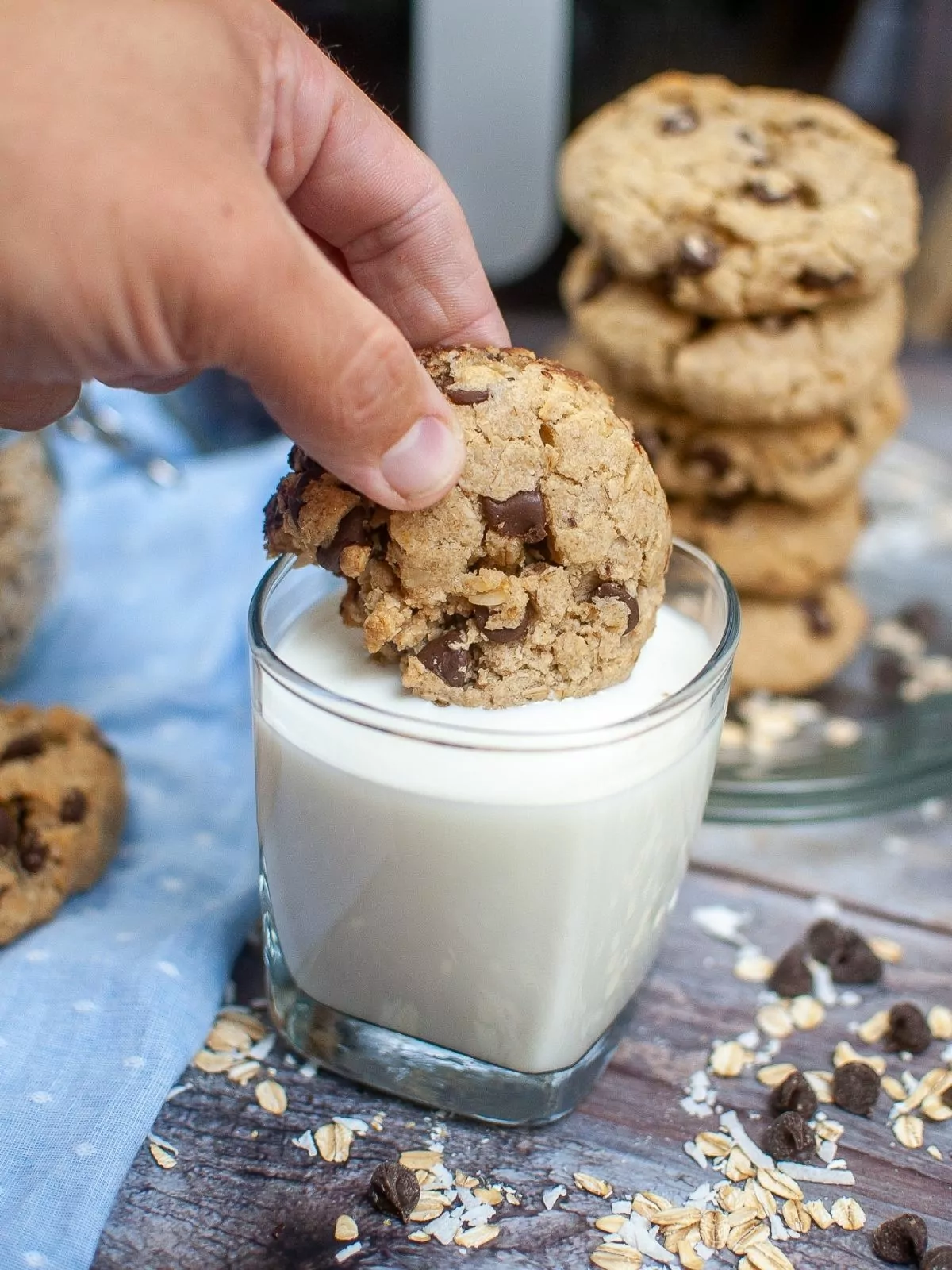 dipping chocolate chip oatmeal cookies in glass of milk.