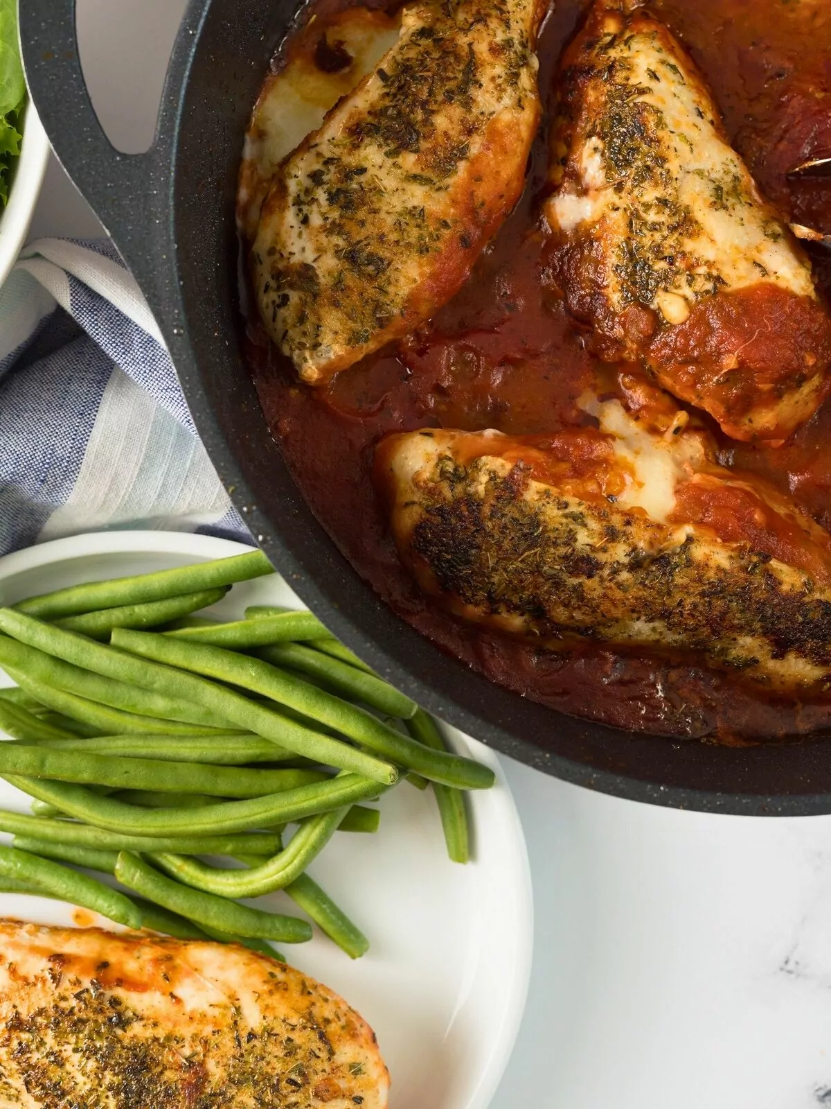 chicken breasts in skillet with tomato sauce.
