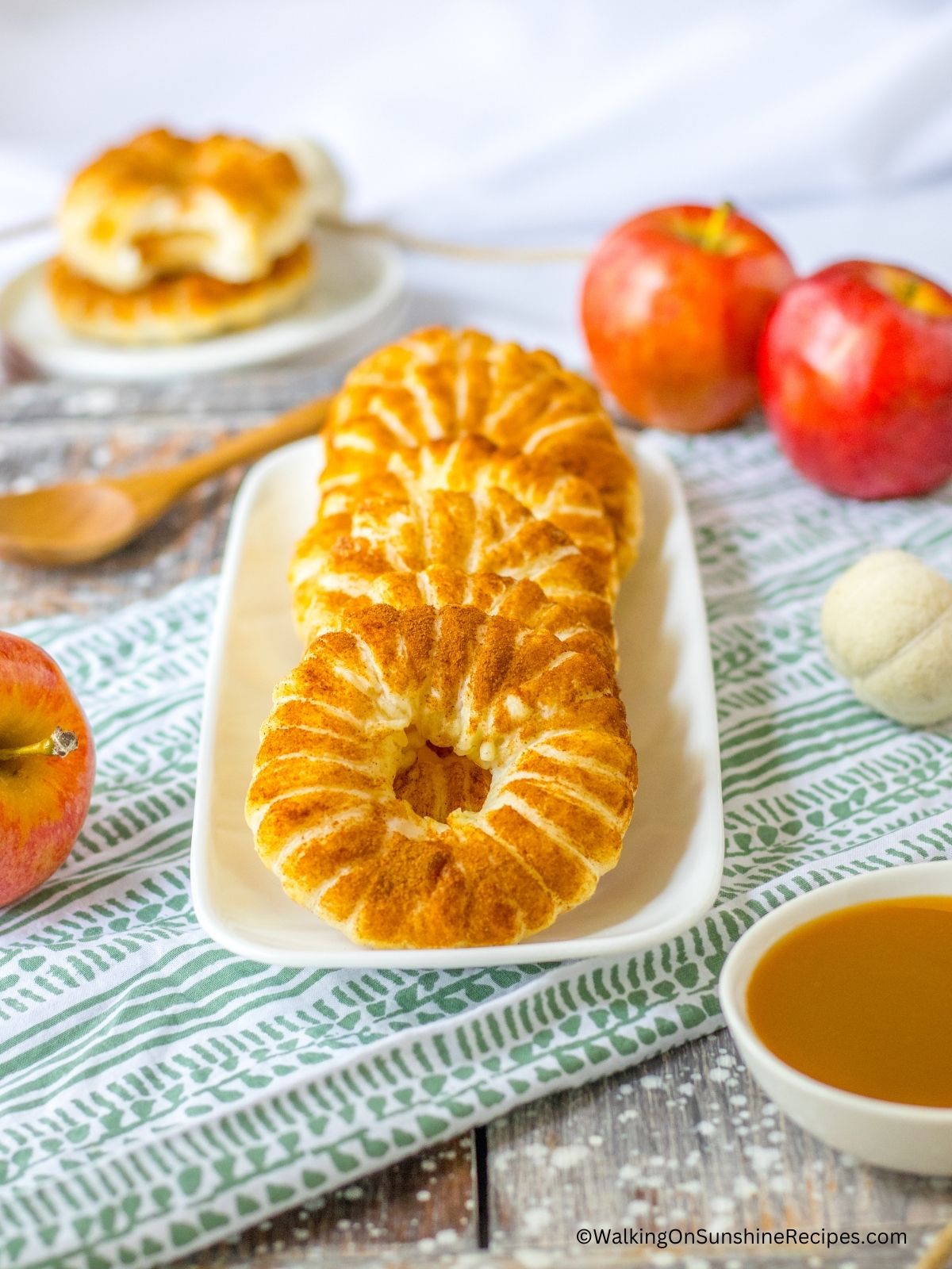 apple puff pastry rings on white plate.
