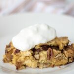 apple dump cake with whipped cream on plate.