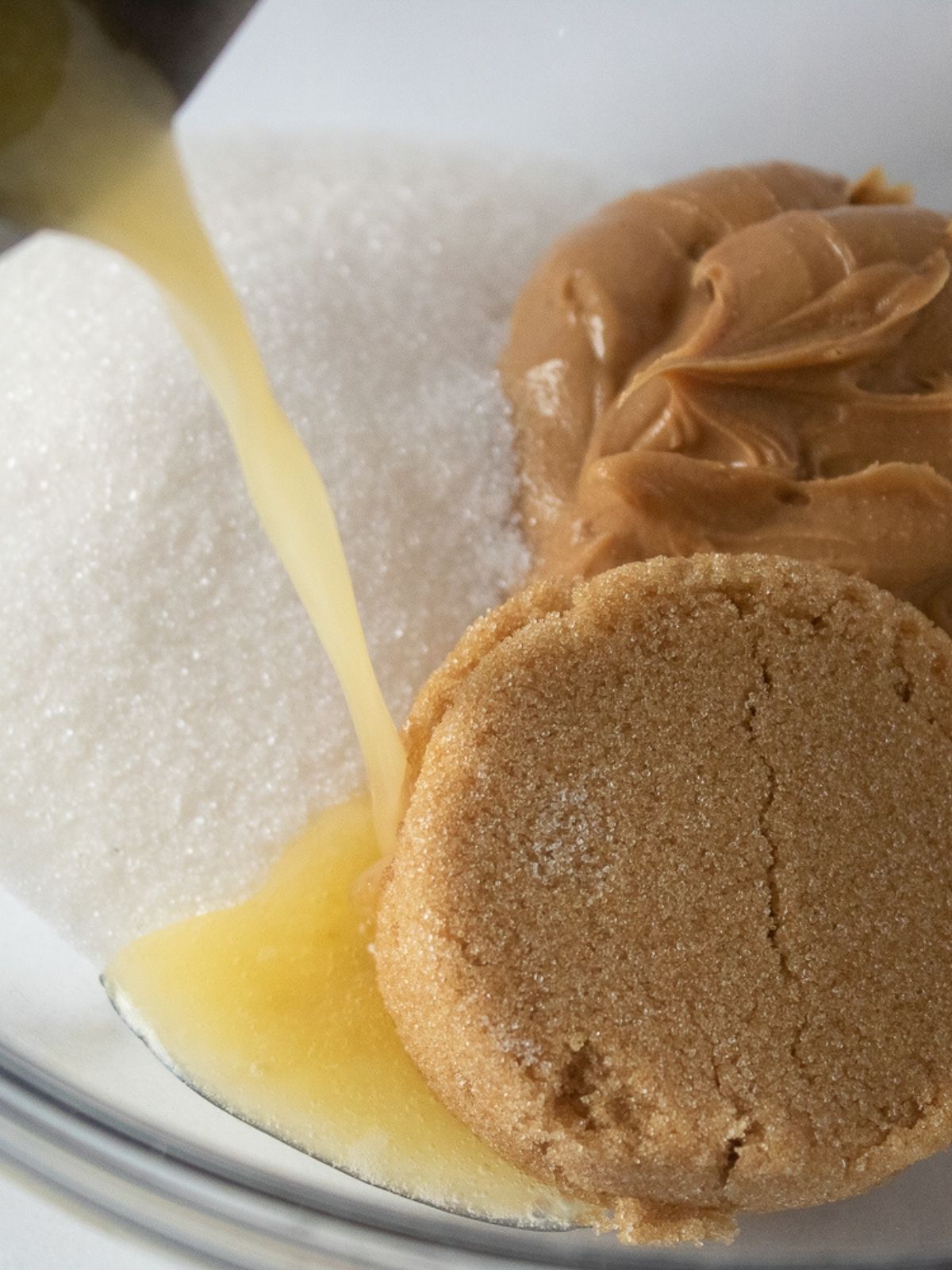 Add melted butter to sugar and peanut butter in bowl.