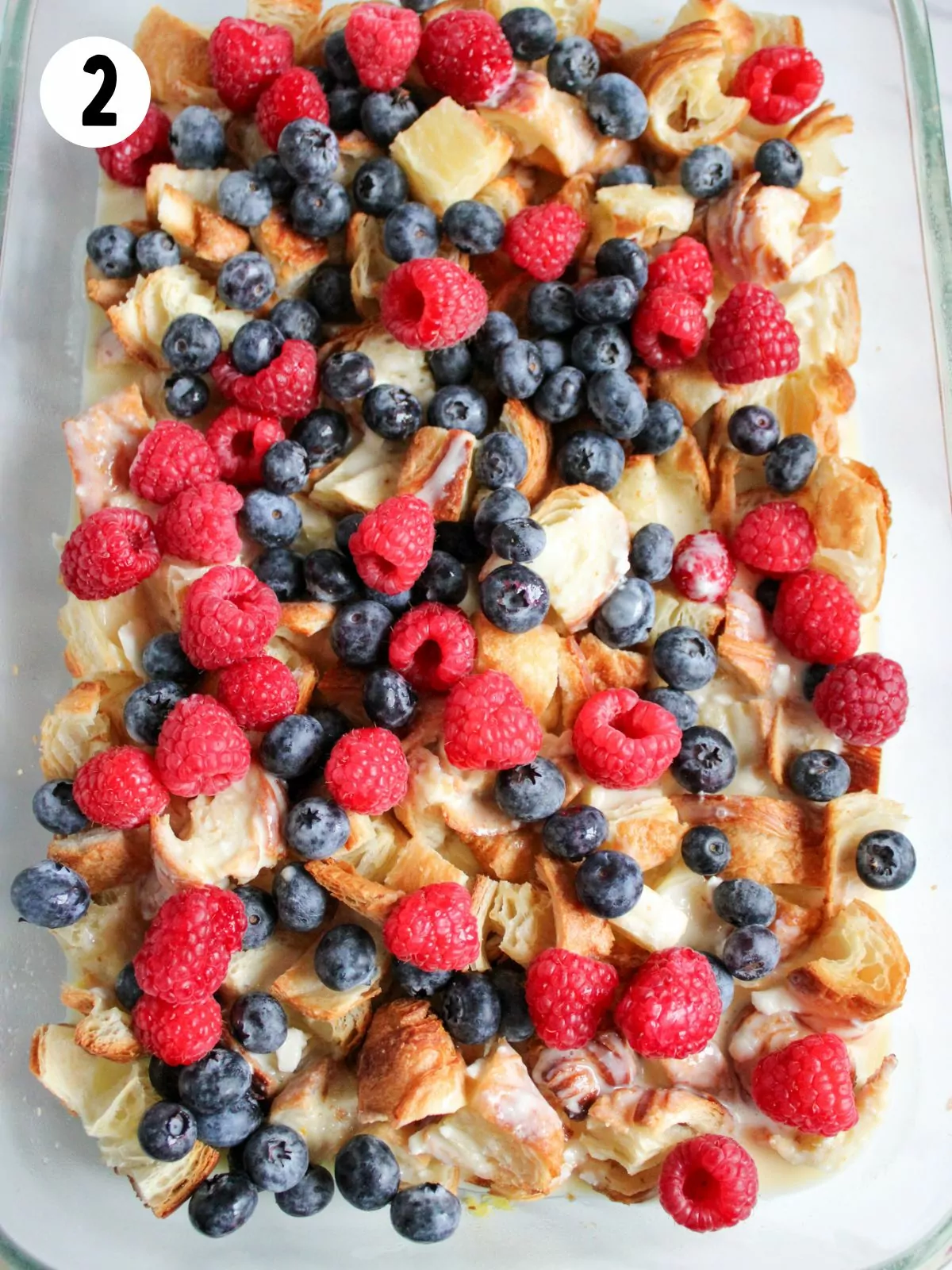 breakfast casserole with croissants and fruit before baking.