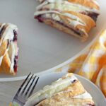 Raspberry Crescent Ring Danish on plate with yellow napkin and fork. Pinterest.