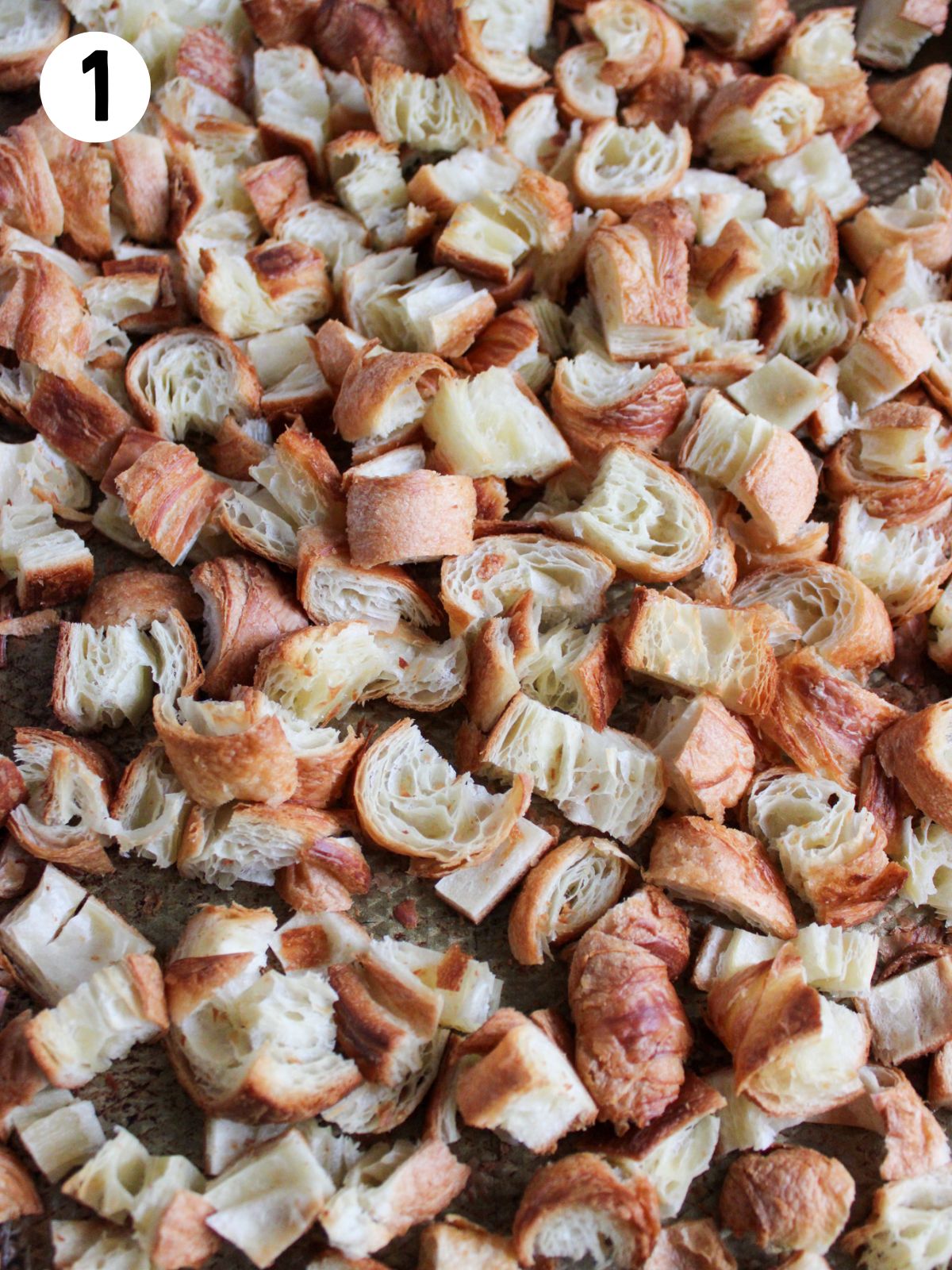 cubed croissants in casserole dish.
