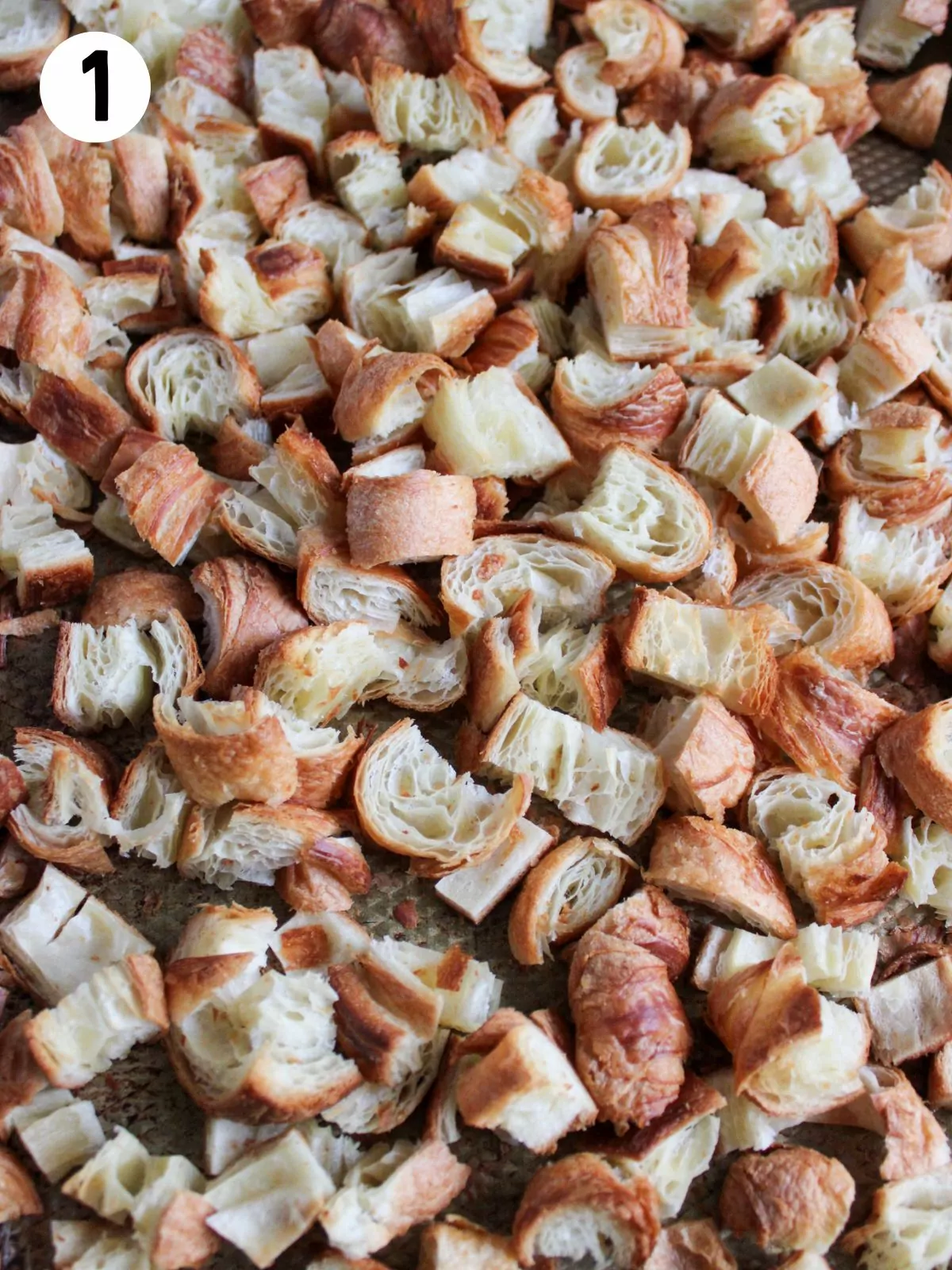 cubed croissants in casserole dish.