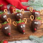 reindeer snack from strawberries and pretzels on cutting board.