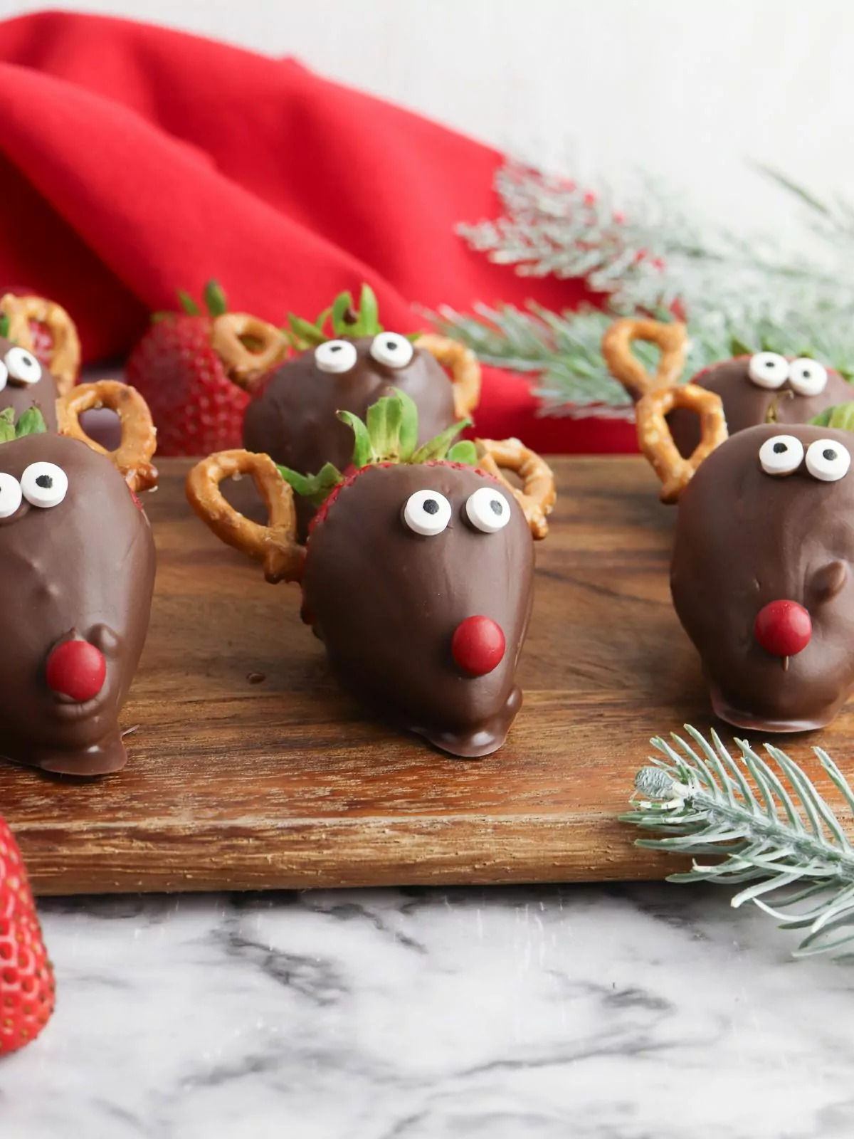reindeers made from strawberries on cutting board.