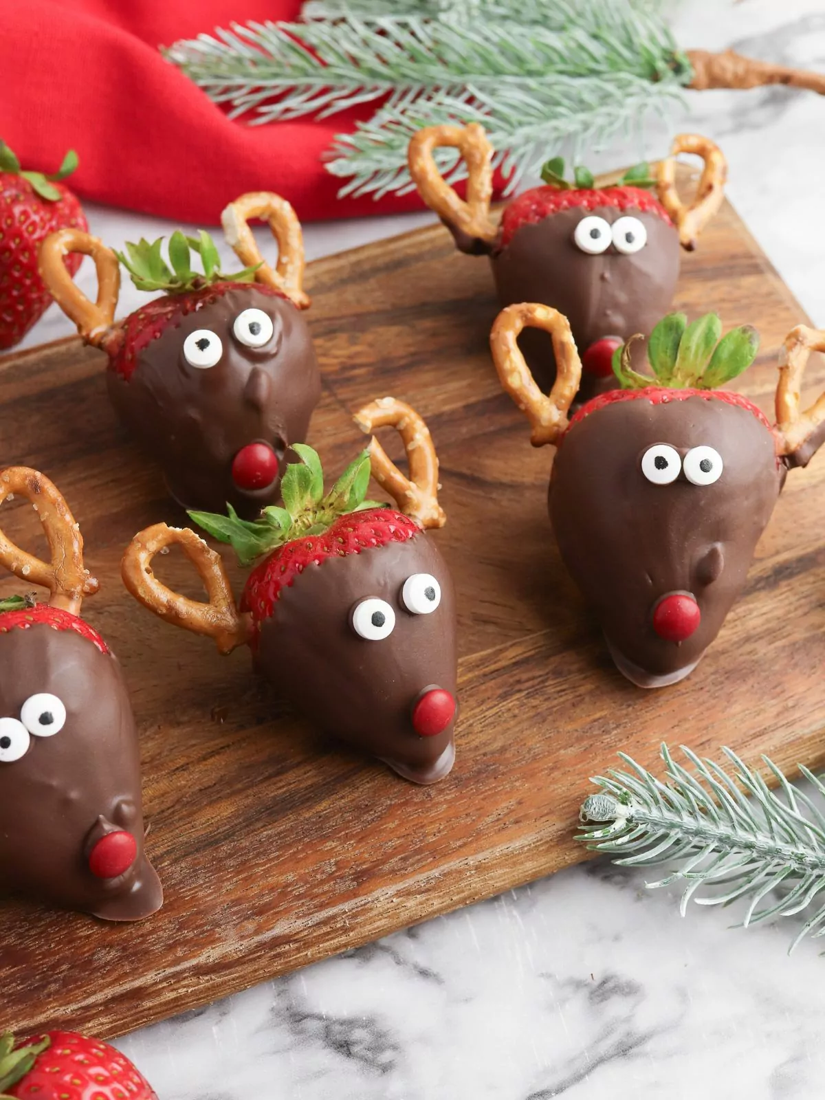 strawberries dipped in chocolate with pretzel antlers and candy eyes.