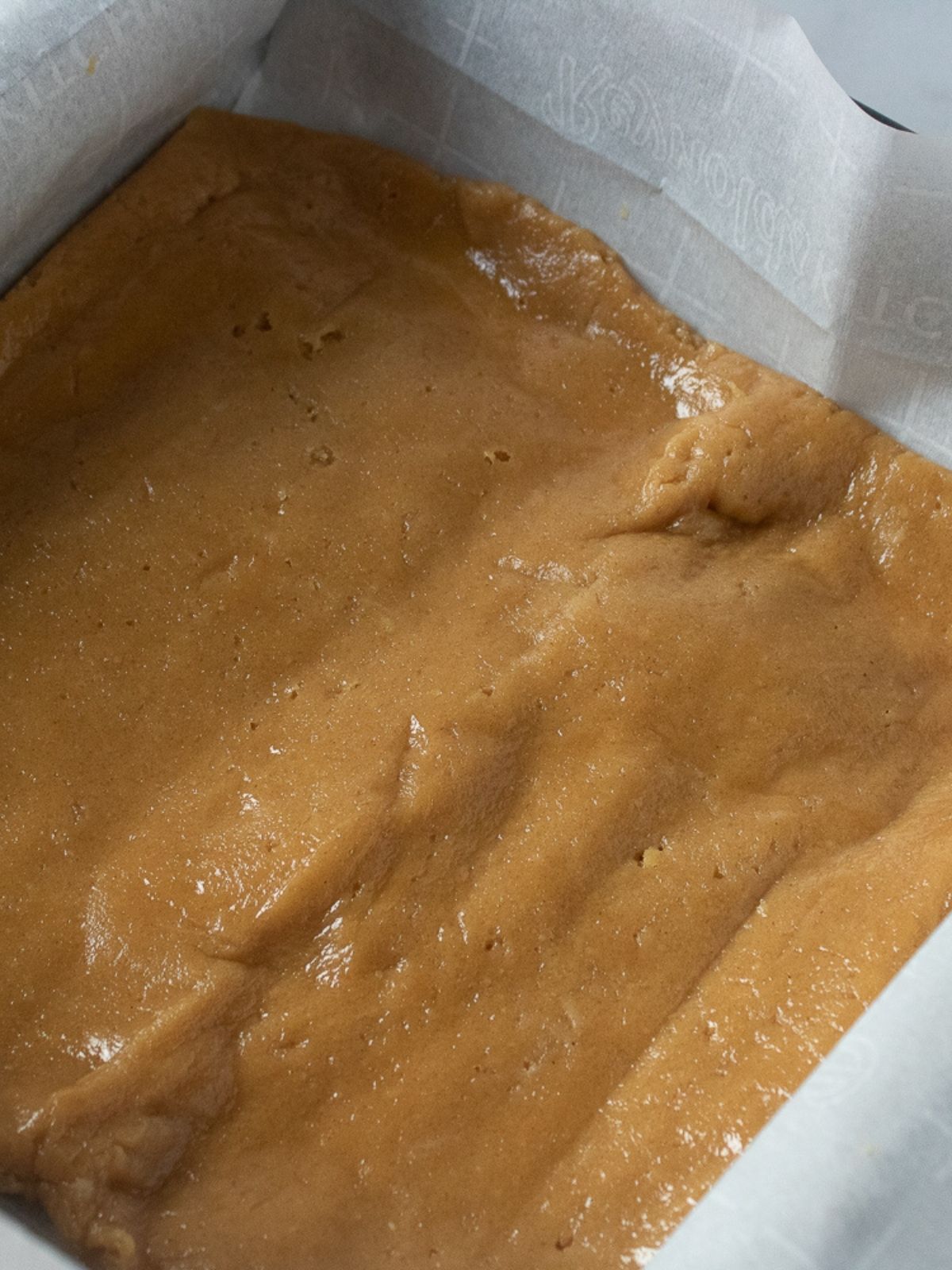 peanut butter layer in pan with parchment paper.