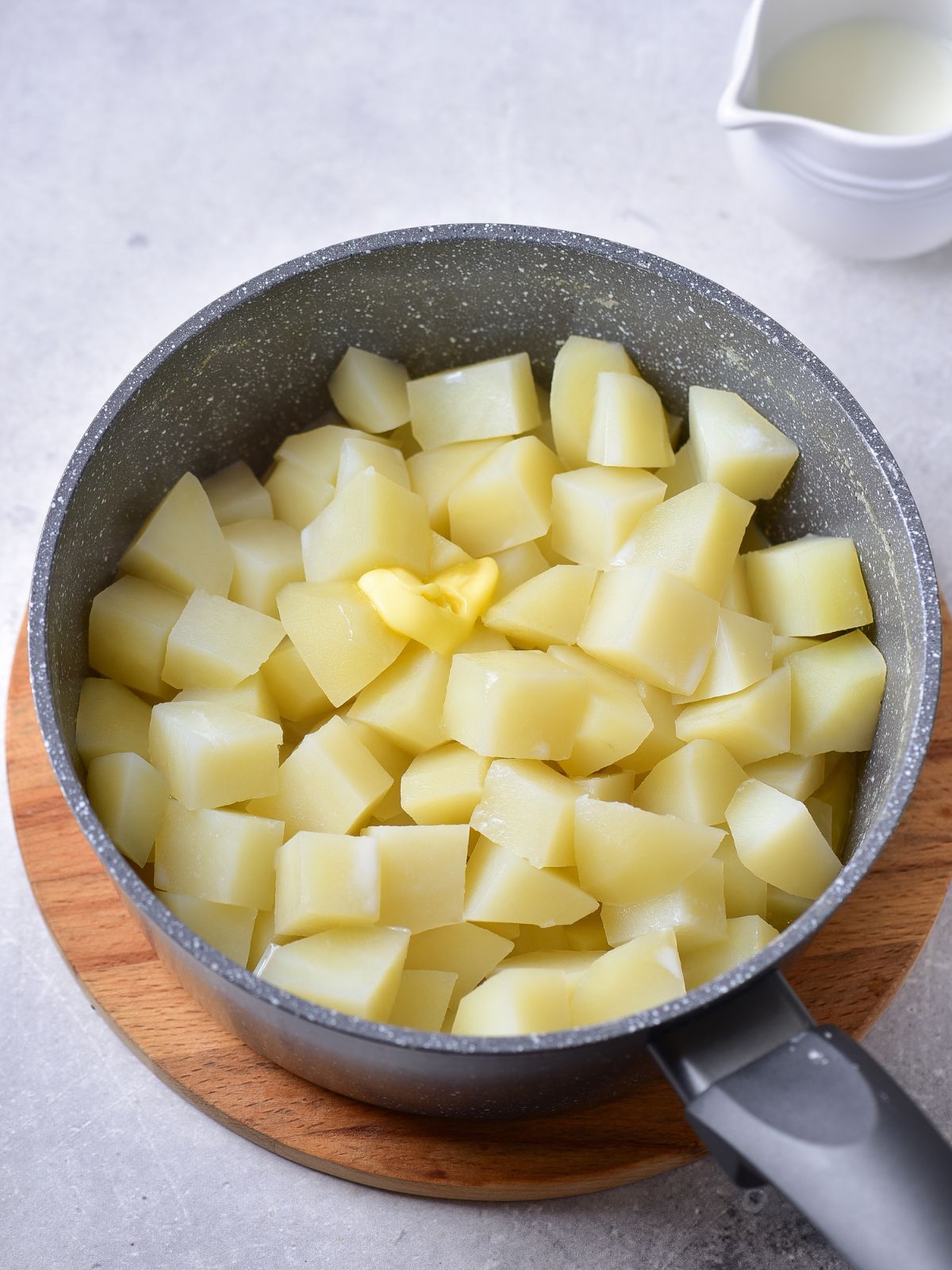 peeled quartered potatoes in pot.