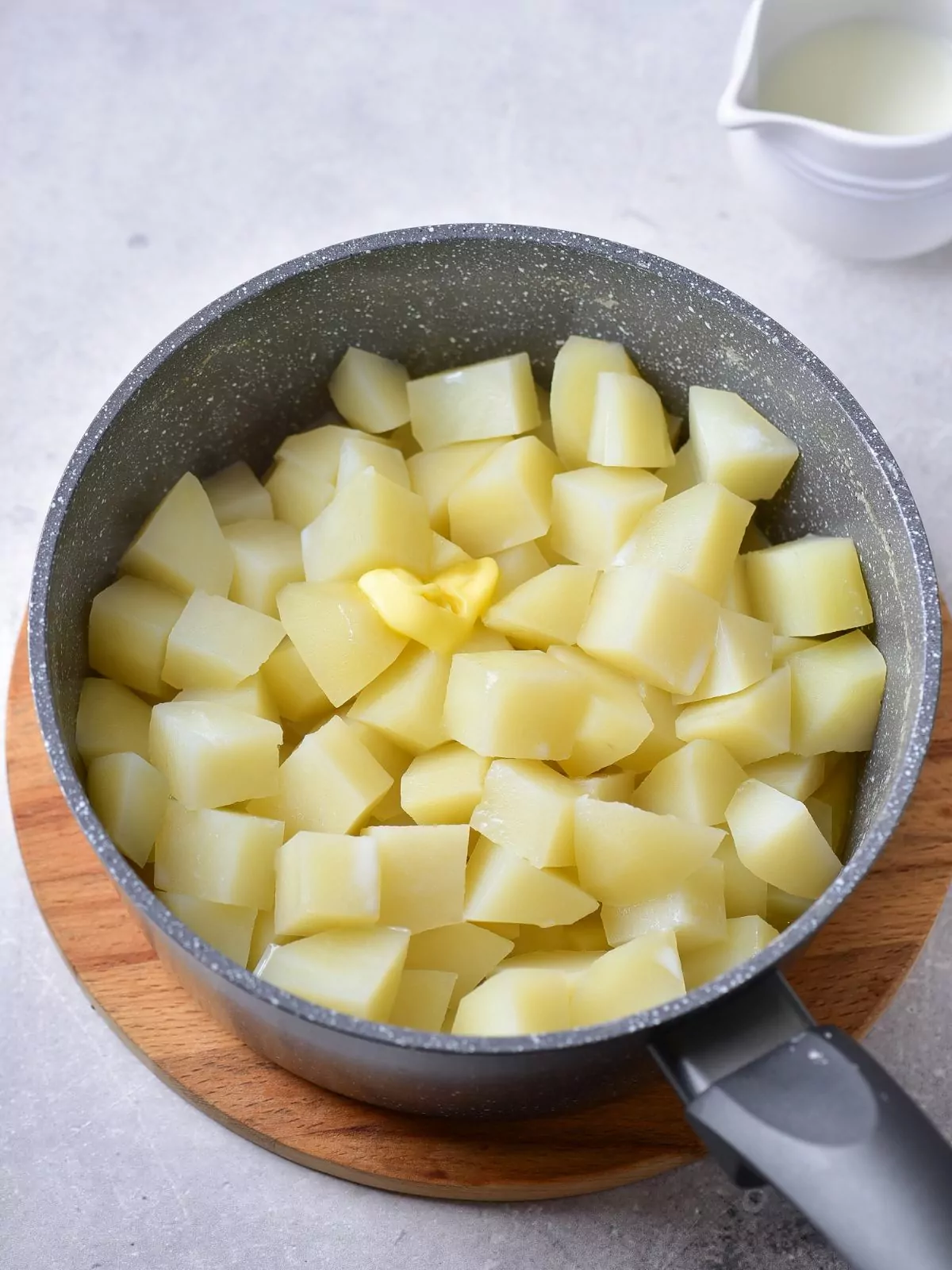 peeled quartered potatoes in pot.