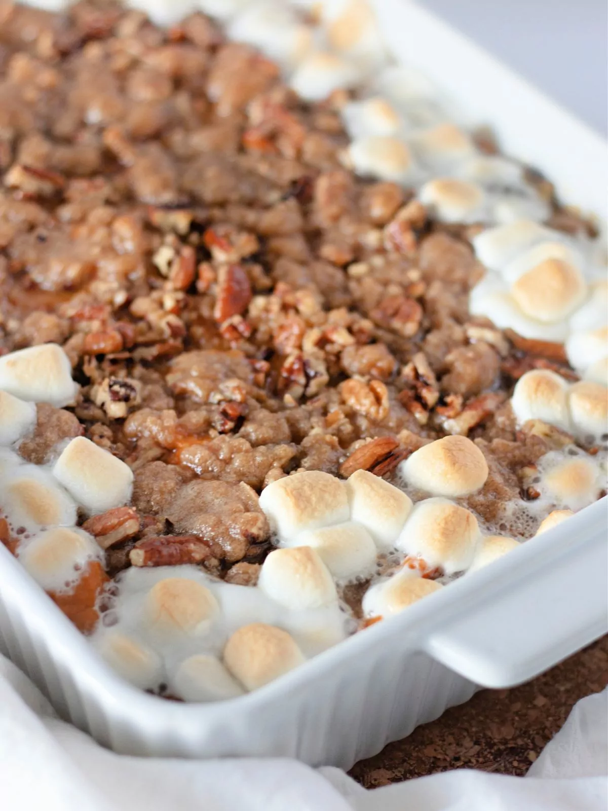 sweet potato casserole in white dish with marshmallows.