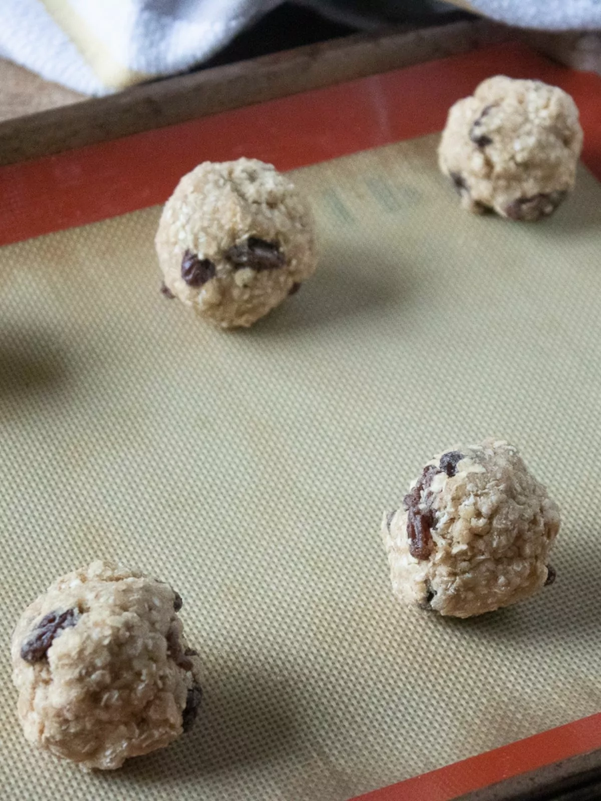 oatmeal raisin cookie dough balls on baking tray.
