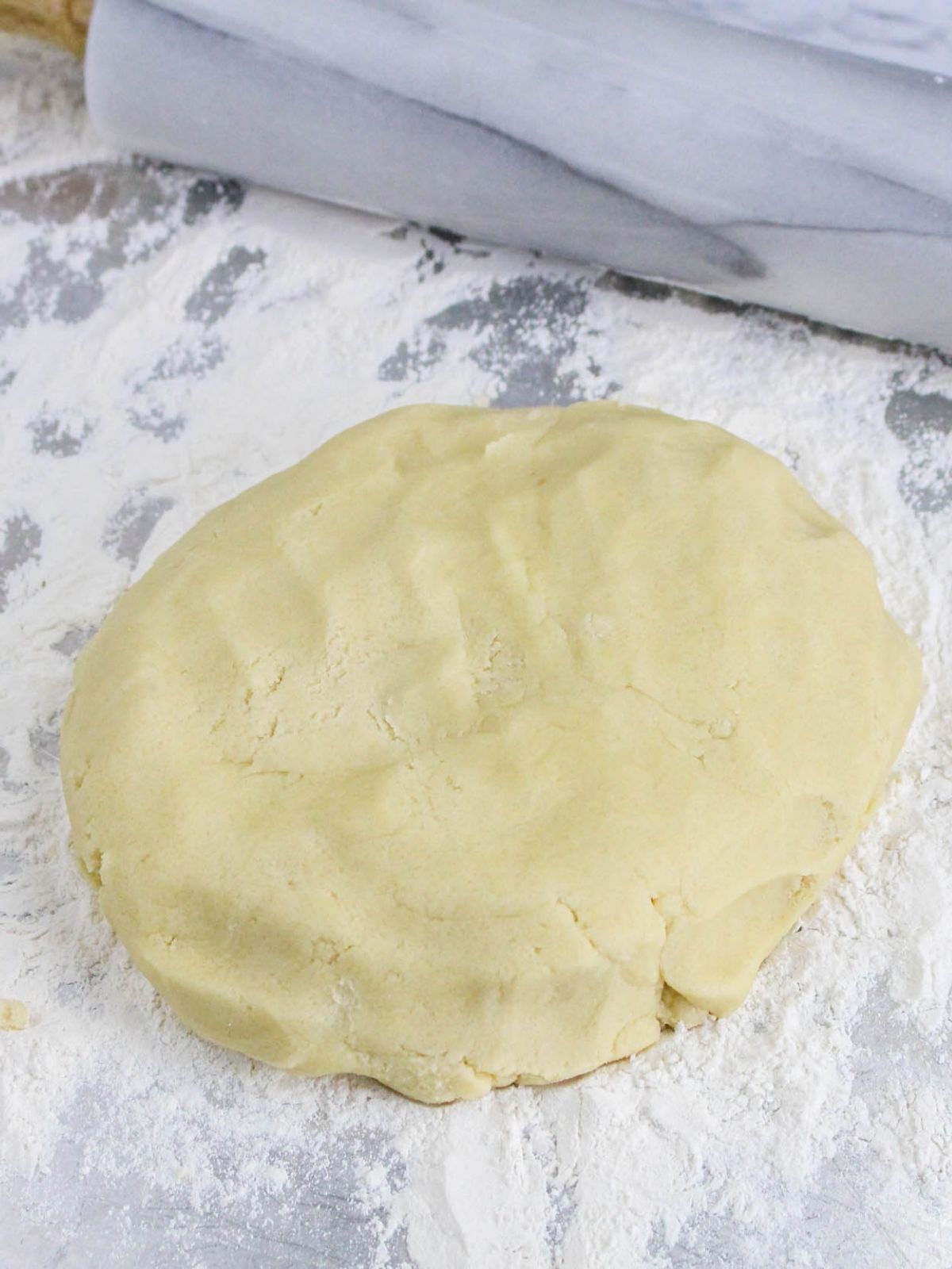cookie dough on floured surface with rolling pan.