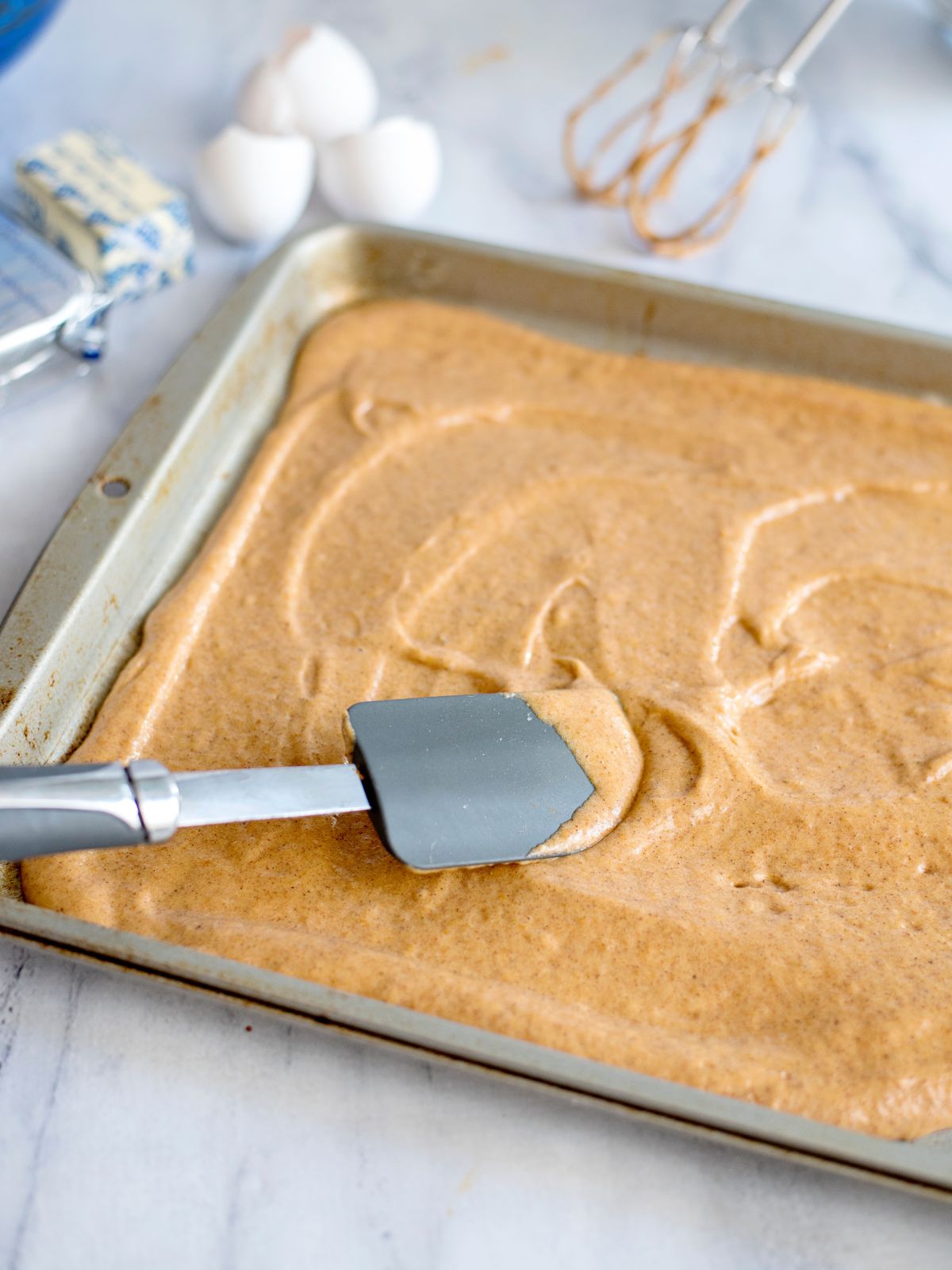spread cake batter in baking tray.