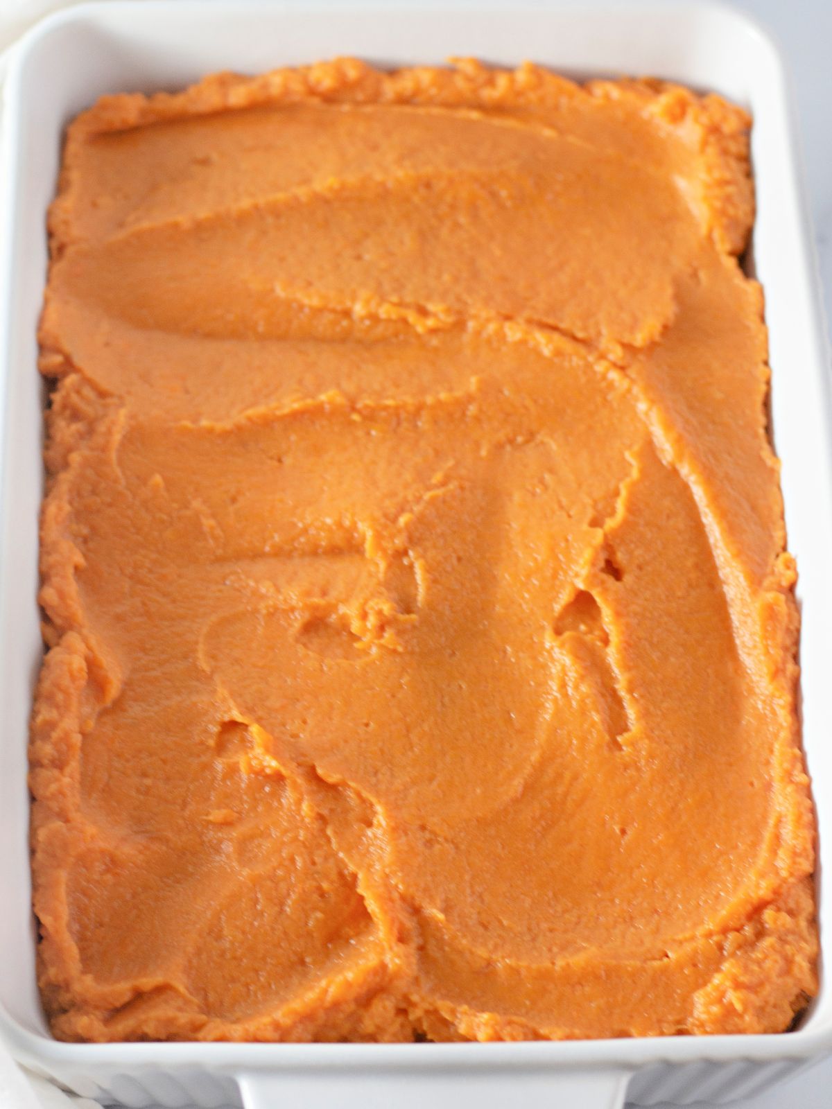 sweet potatoes spread in casserole dish.