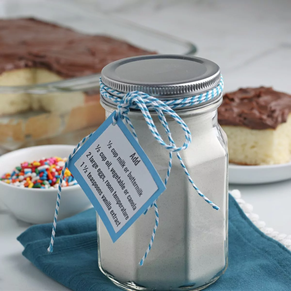 cake mix in a mason jar with blue gift tag.