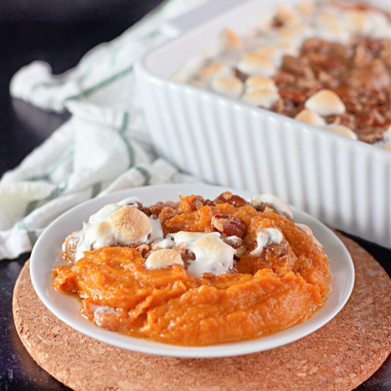 sweet potato casserole with marshmallows and pecans in small white bowl.