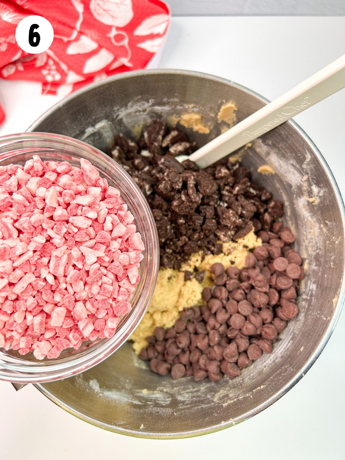 Peppermint baking chips in small bowl over bowl of cookie dough.