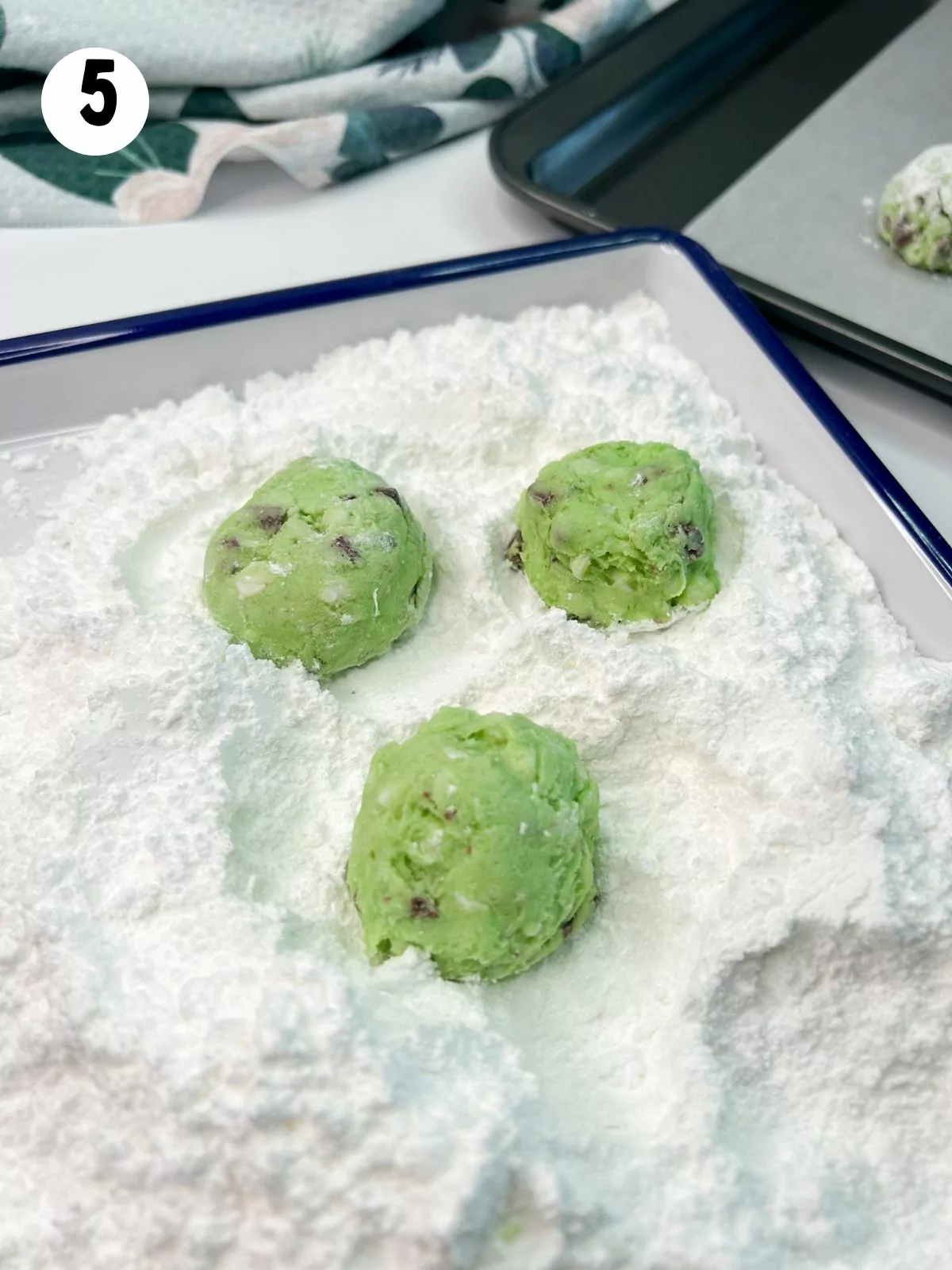 green tinted cookie balls rolled in powdered sugar.