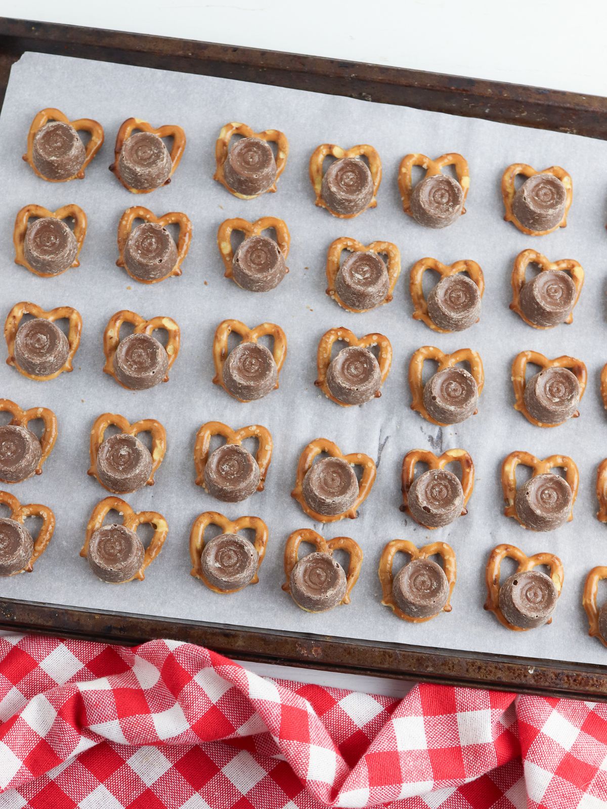Add Rolo candies to pretzel twists.
