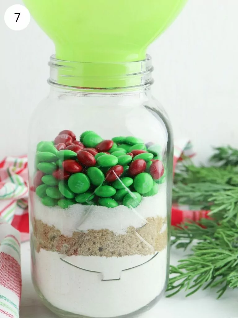 green funnel in mason jar with cookie ingredients.