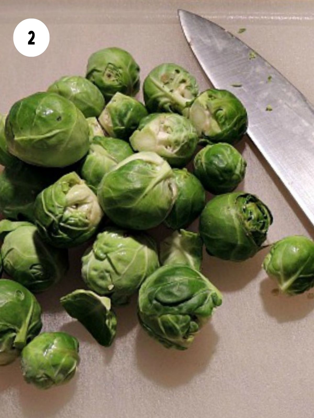 Prepare Brussels sprouts on cutting board with knife.