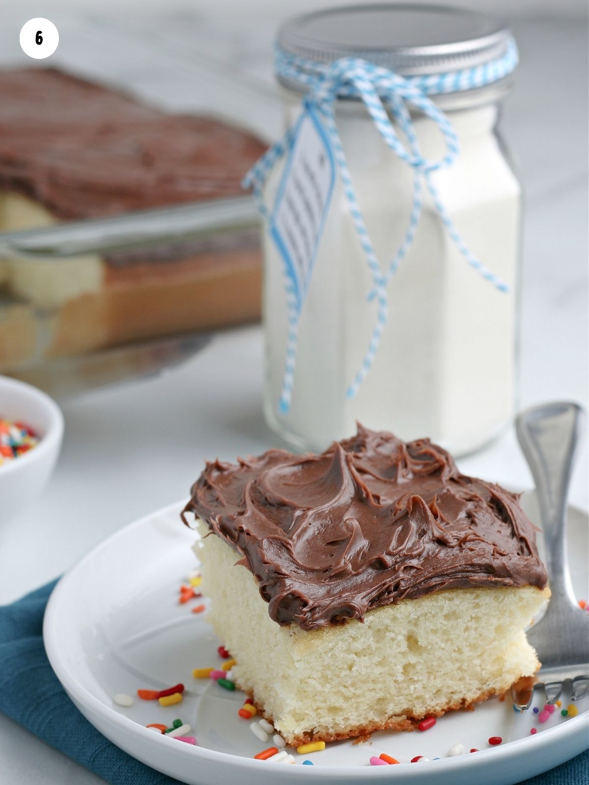 vanilla cake with chocolate frosting on white plate.
