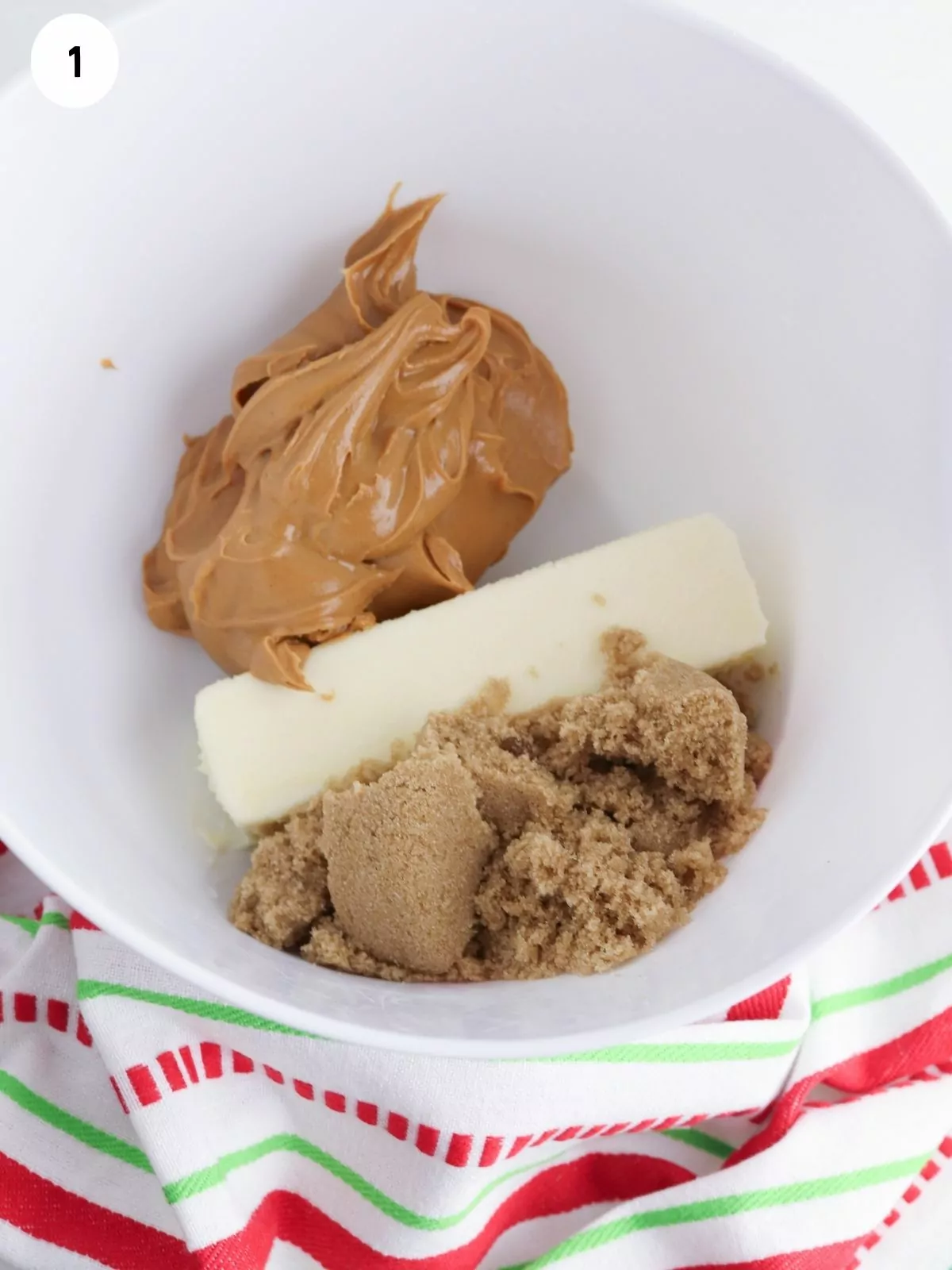 Peanut butter, butter in bowl with sugar.
