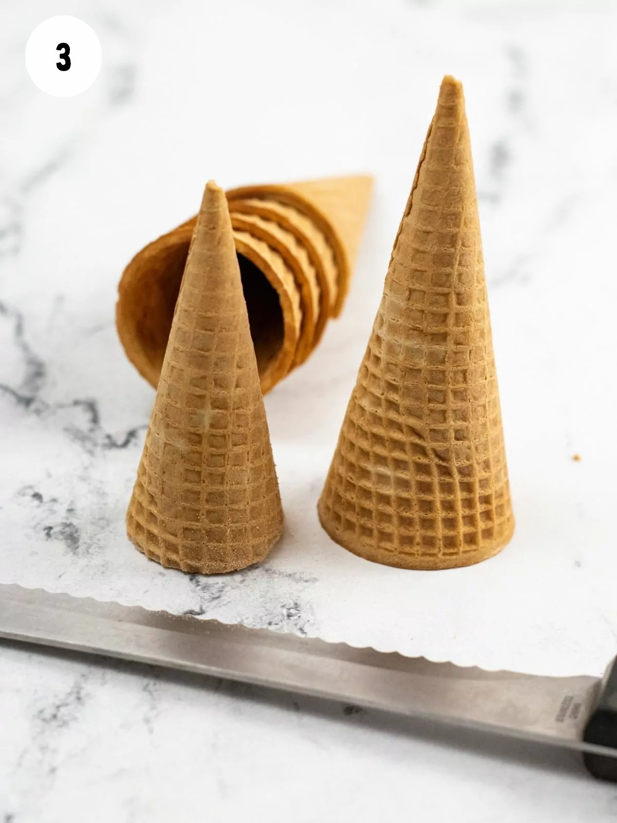 Ice cream cones with serrarted knife.