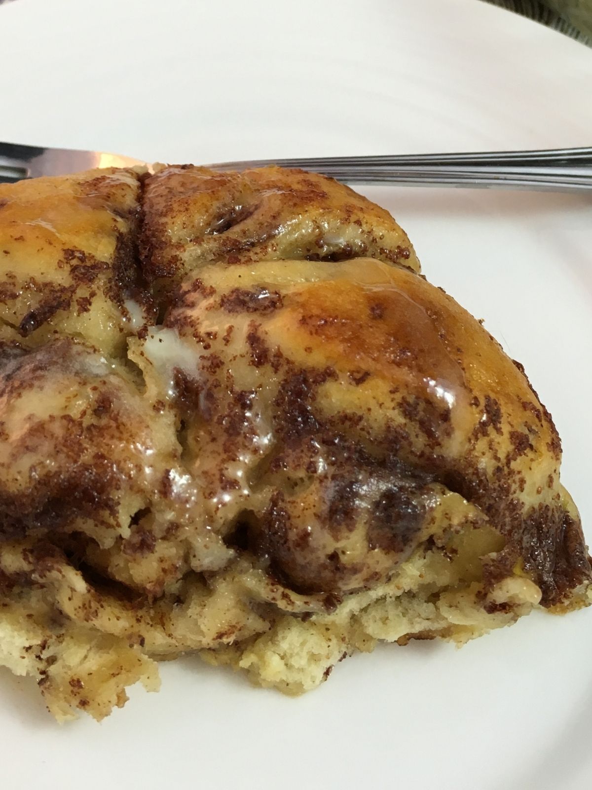 cinnamon roll casserole served on white plate closeup.