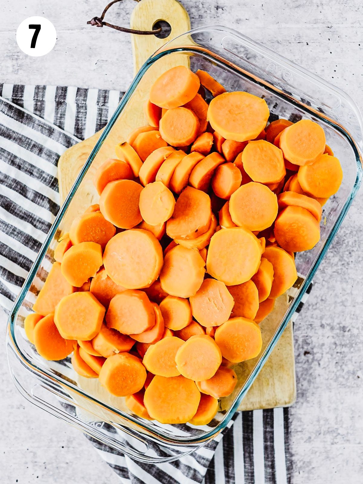 sliced sweet potatoes in casserole dish.