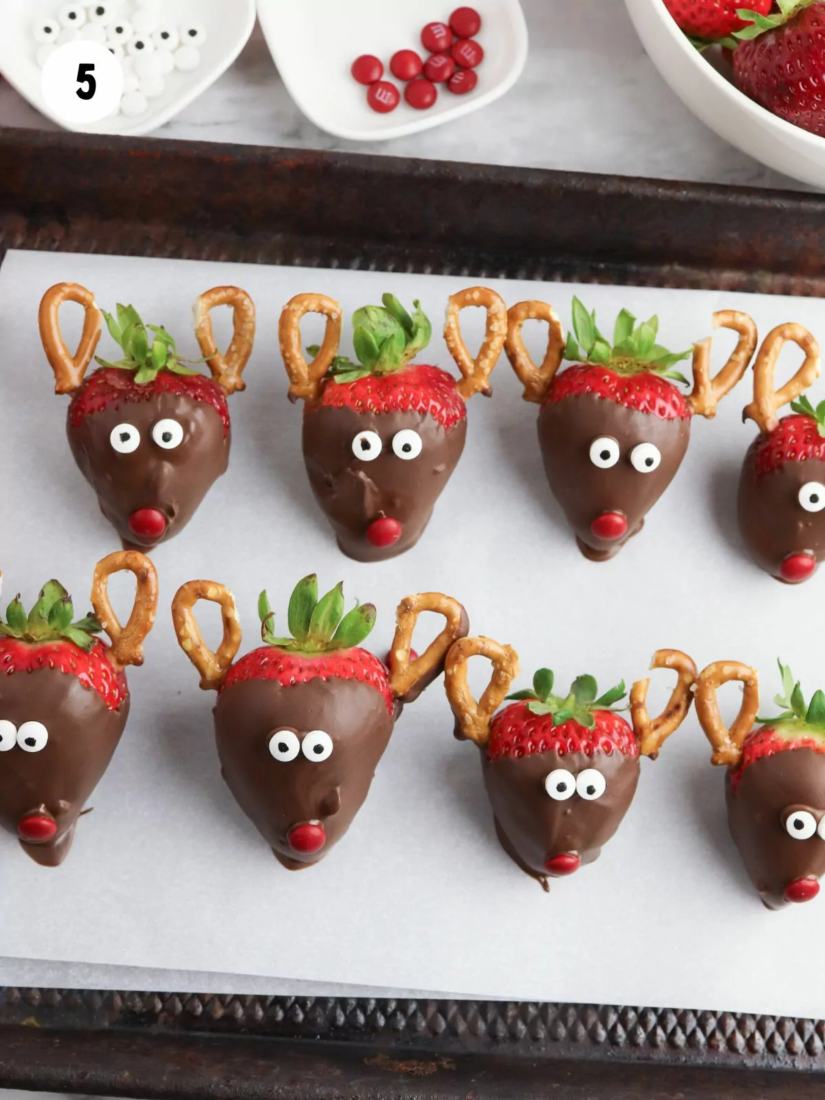 strawberry reindeers on parchment lined baking tray.