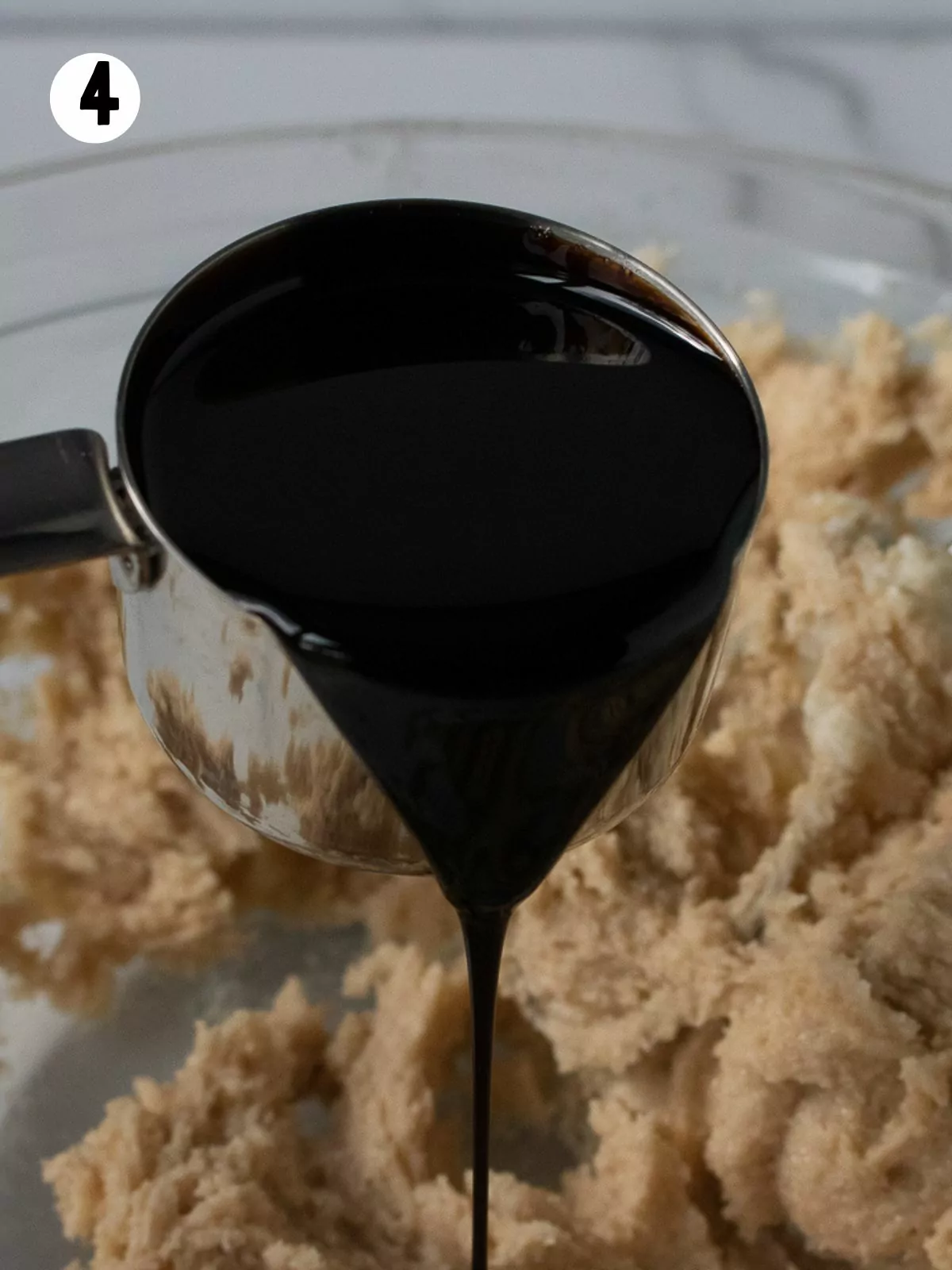 Dark molasses in measuring cup.