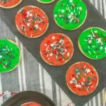 Christmas cookies with red and green frosting topped with Christmas sprinkles