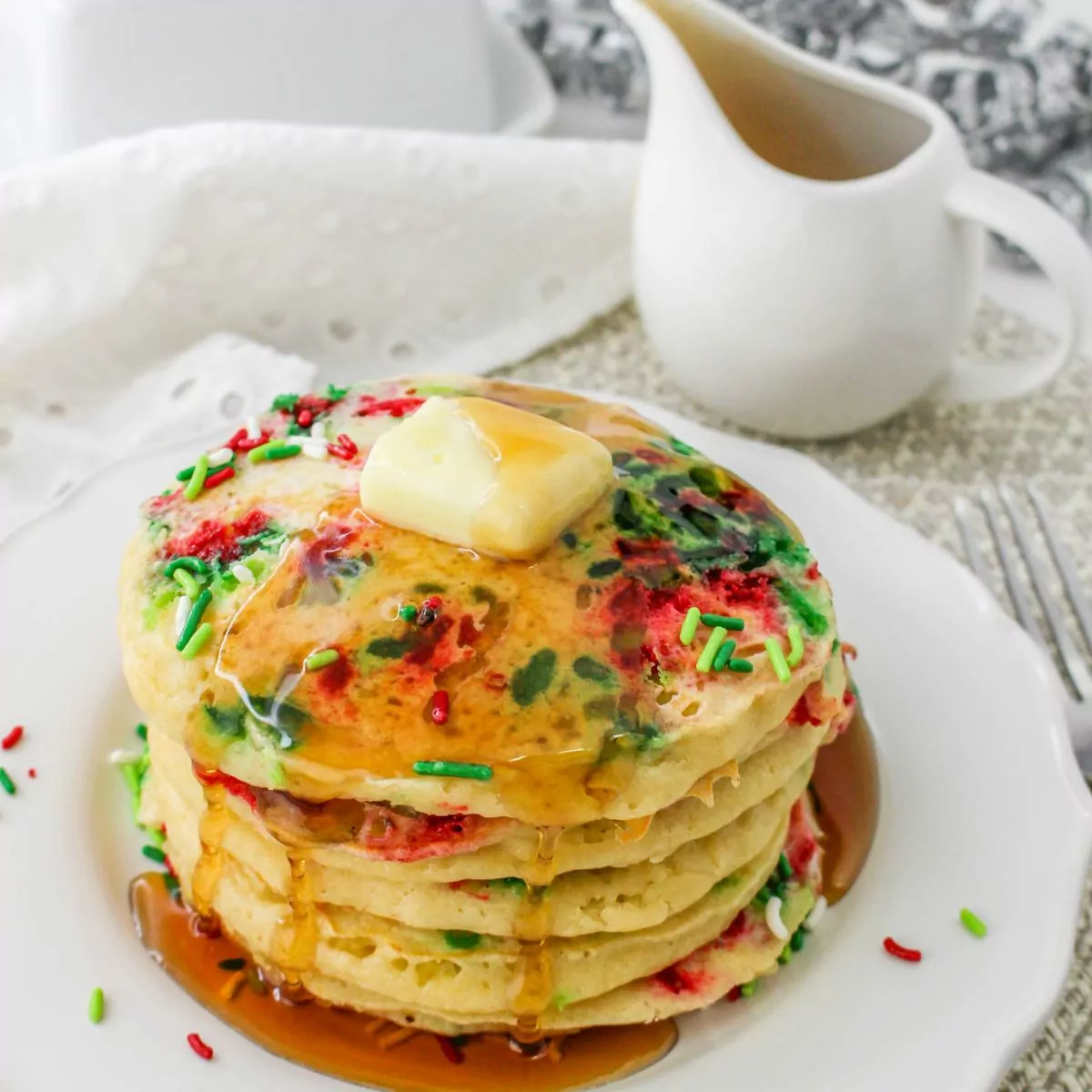 pancakes with sprinkles on white plate.