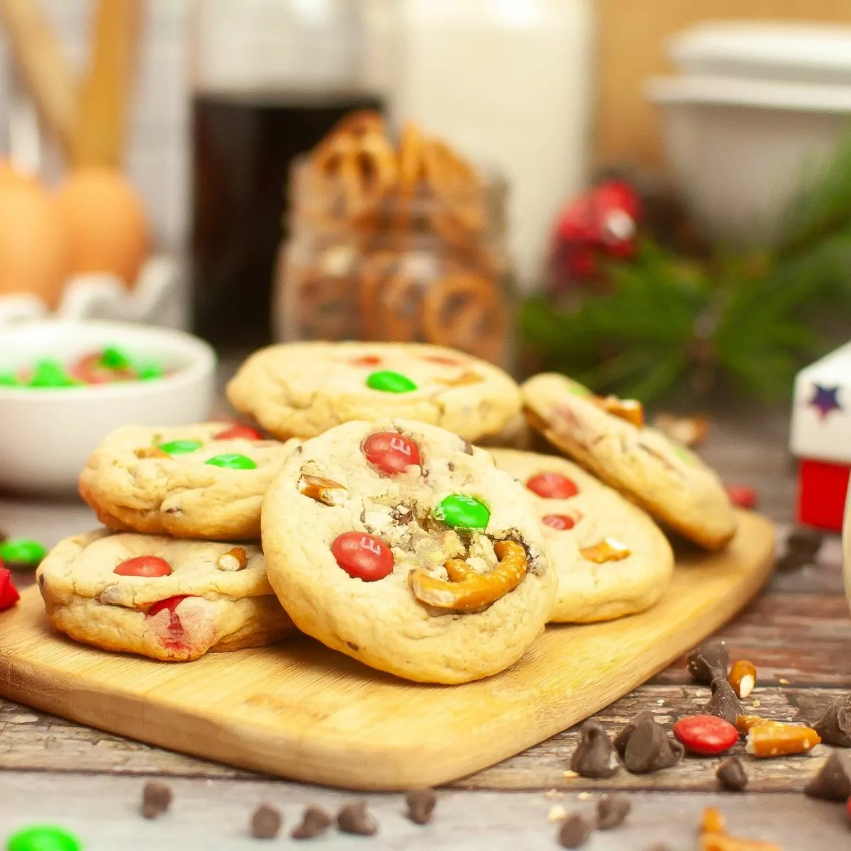 Christmas cookies with pretzels and M&Ms on cutting board.