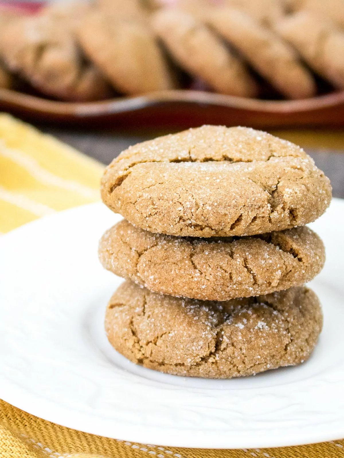 Stacked gingersnap cookies on white plate.