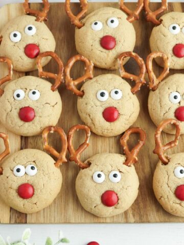 Reindeer cookies displayed on a wooden board.