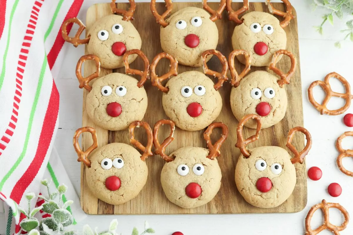 Reindeer cookies displayed on a wooden board.