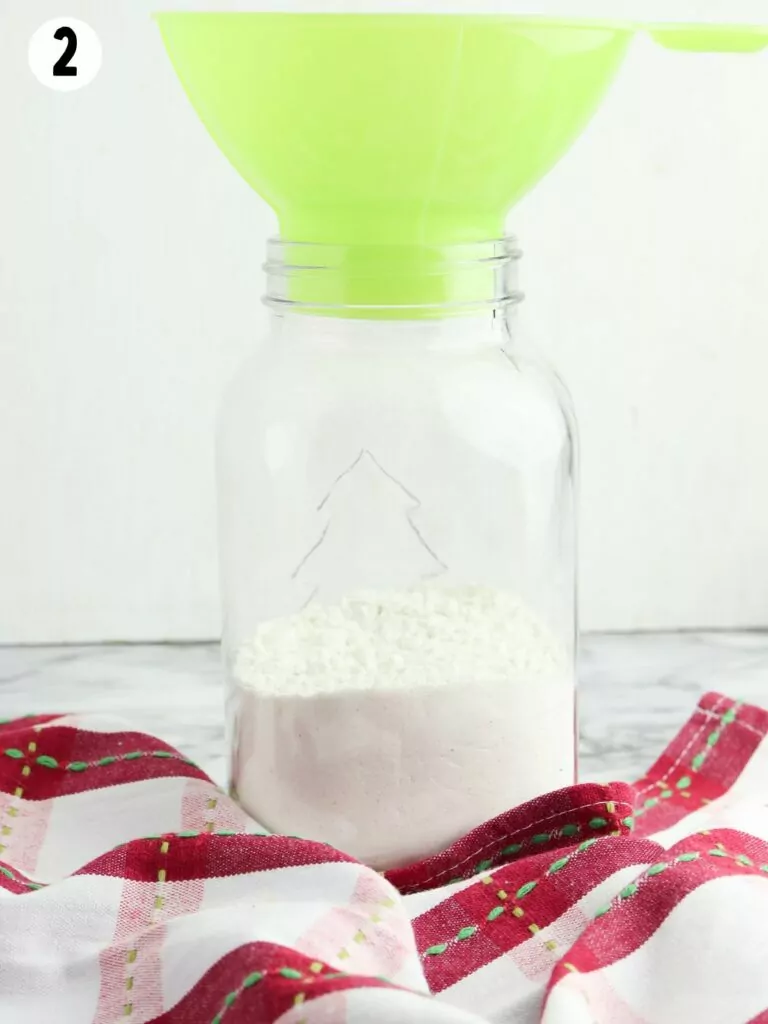 add dry ingredients to mason jar with green funnel.