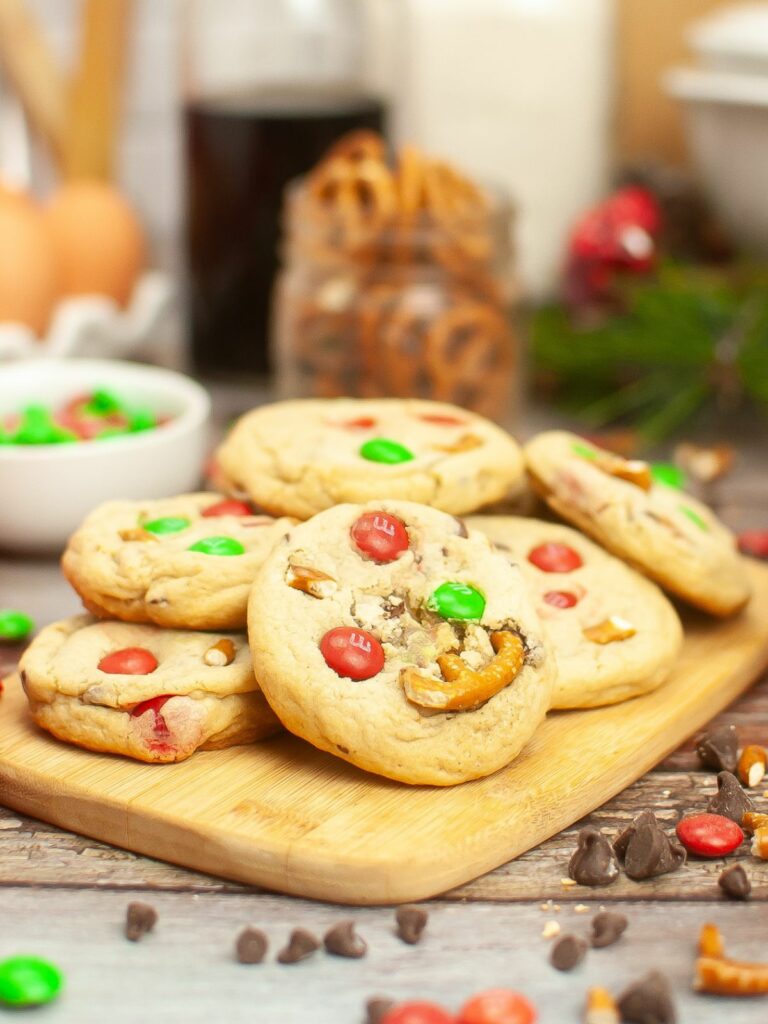Christmas cookies with pretzels on cutting board.