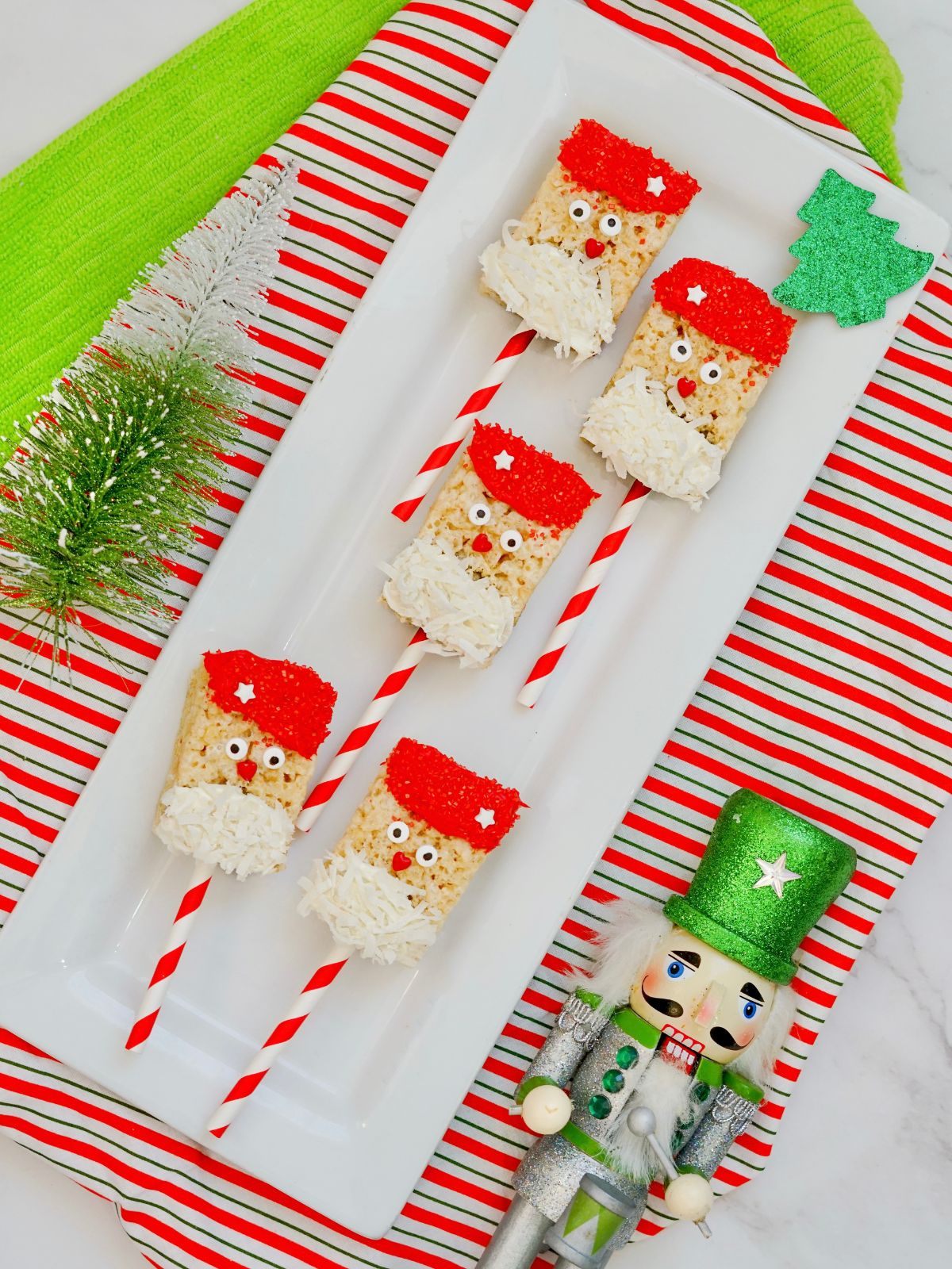Santa treats on white plate with nutcracker laying beside.