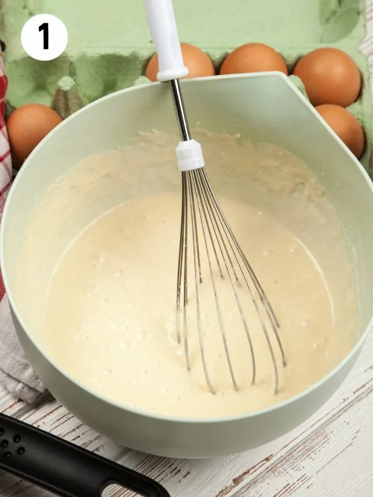 pancake batter in bowl with whisk.