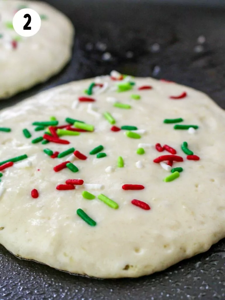 homemade pancakes on griddle with Christmas sprinkles.